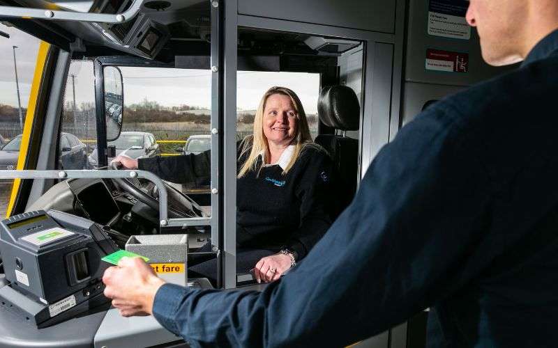 Bus driver greeting a customer