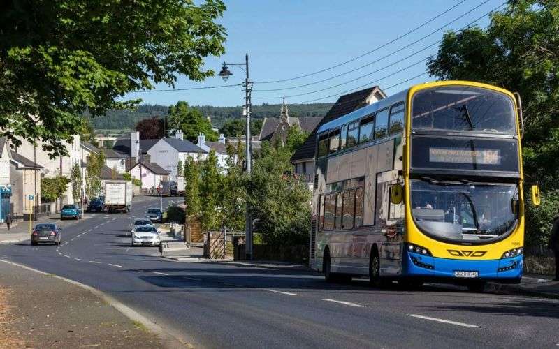 A bus riding through a village