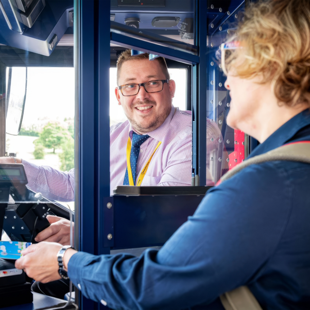 Bus driver greeting a customer